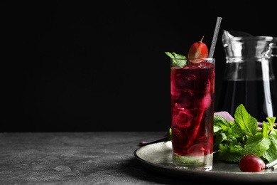 Photo of Delicious grape soda water with mint on grey table, space for text. Refreshing drink