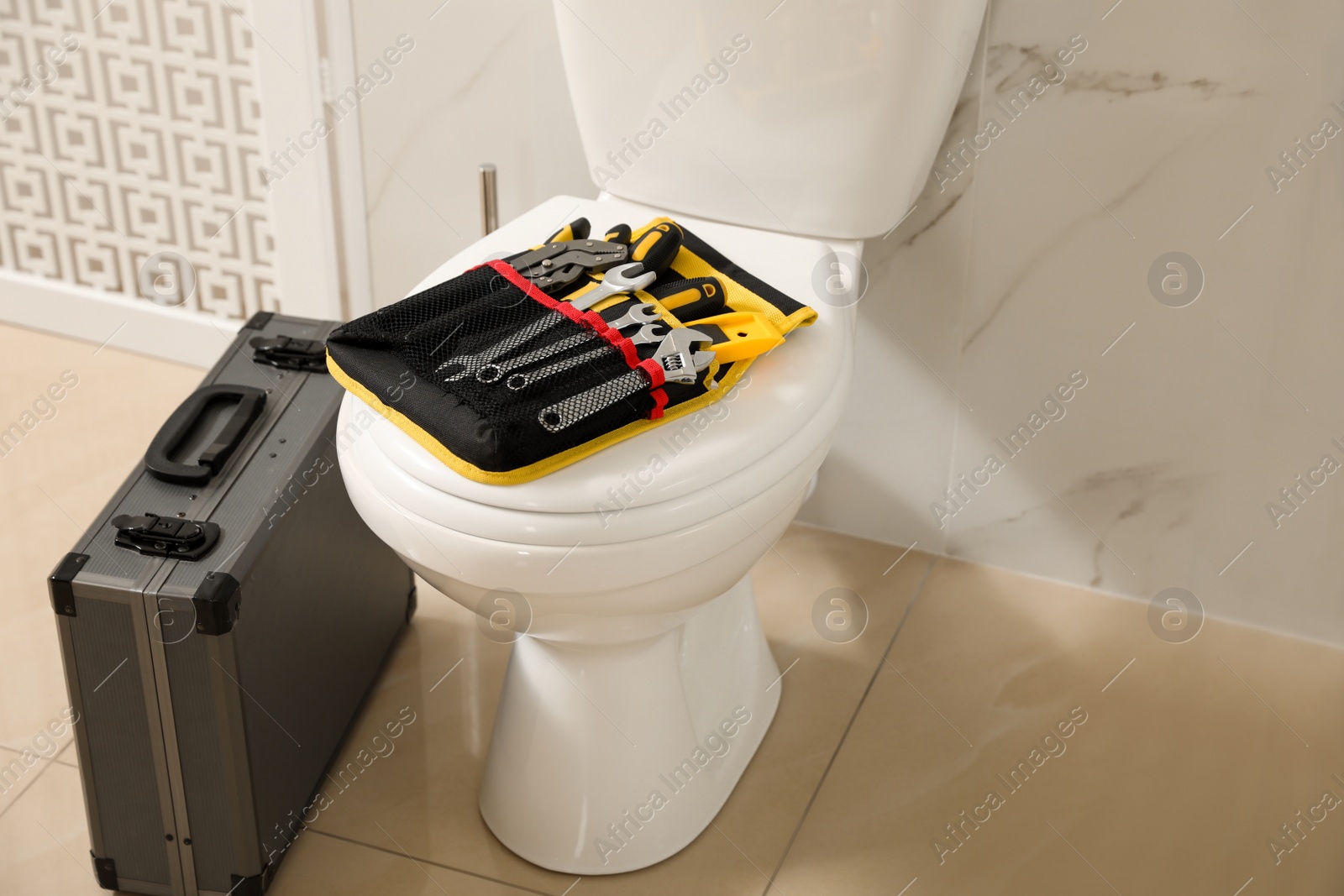 Photo of Plumber's tools on toilet bowl in bathroom