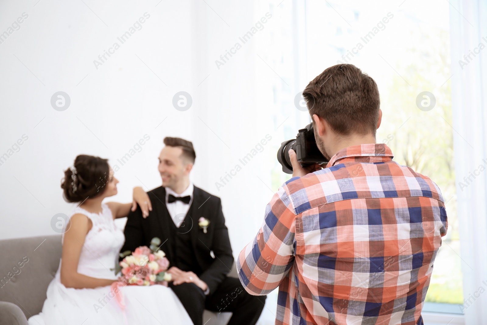 Photo of Professional photographer taking photo of wedding couple in studio