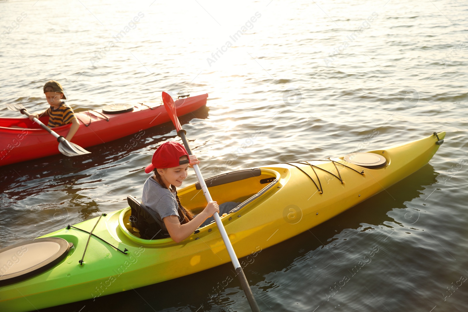 Photo of Little children kayaking on river. Summer camp activity