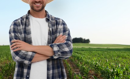 Confident farmer with crossed arms in field, closeup. Harvesting season