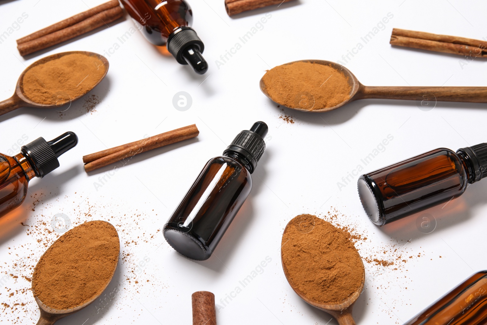 Photo of Composition with cinnamon essential oil on white background