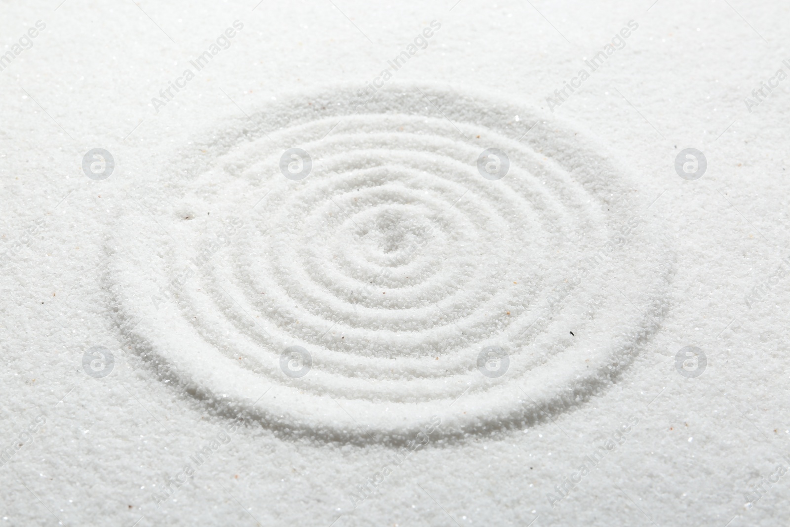 Photo of Zen rock garden. Circle pattern on white sand