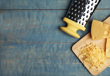 Tasty grated cheese on blue wooden table, flat lay. Space for text