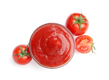 Photo of Tasty ketchup in glass bowl and fresh tomatoes isolated on white, top view