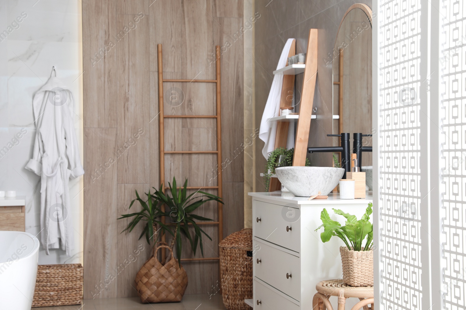 Photo of Chest of drawers with sink and beautiful green houseplants in bathroom. Interior design