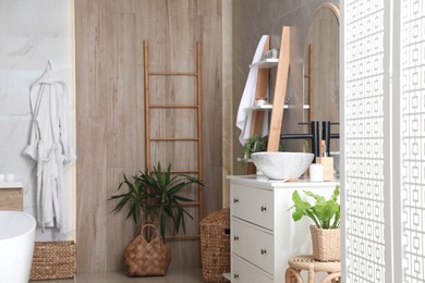 Chest of drawers with sink and beautiful green houseplants in bathroom. Interior design