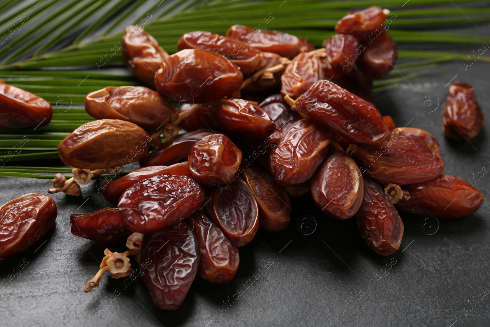 Photo of Tasty sweet dried dates on black table, closeup