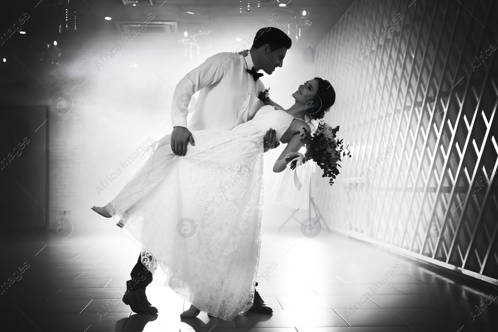 Image of Happy newlywed couple dancing together in festive hall