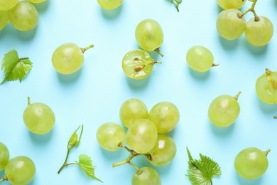 Flat lay composition with fresh ripe juicy grapes on light blue background