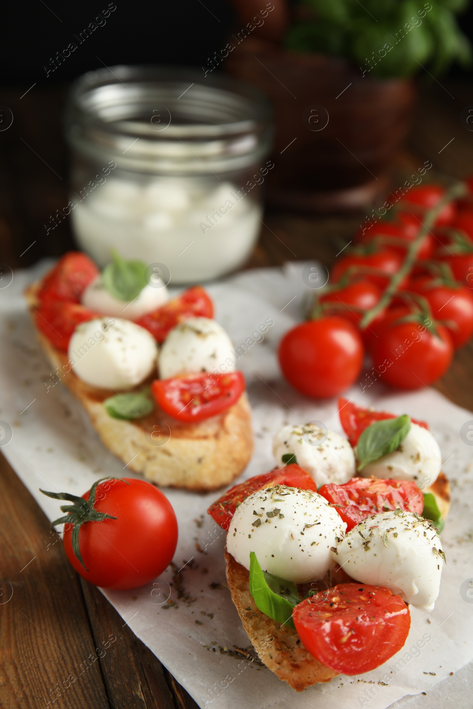 Photo of Delicious sandwiches with mozzarella, fresh tomatoes and basil on wooden table 