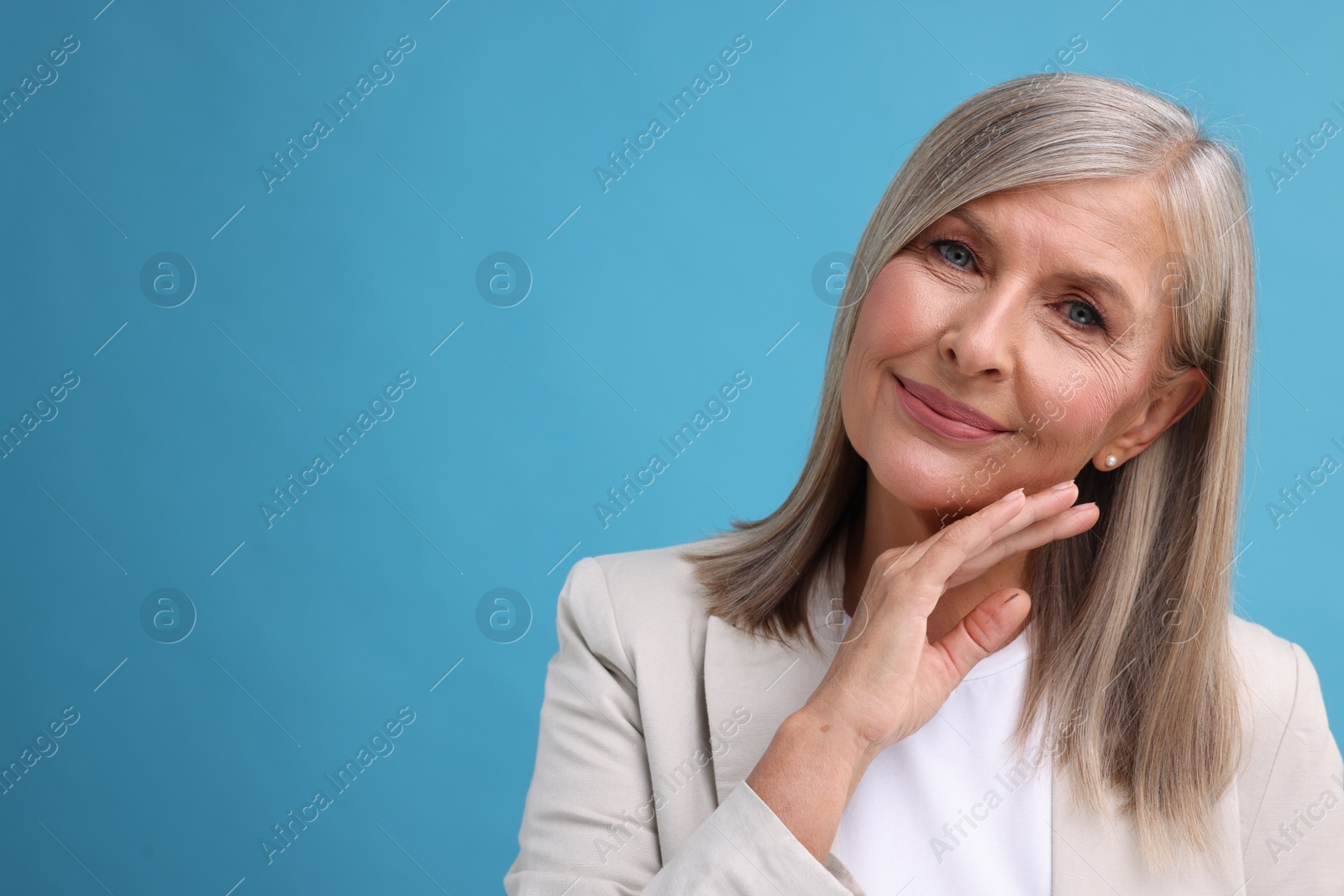 Photo of Portrait of beautiful middle aged woman on light blue background, space for text