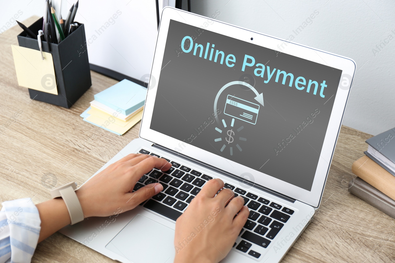 Image of Woman using laptop for online payment at wooden table, closeup