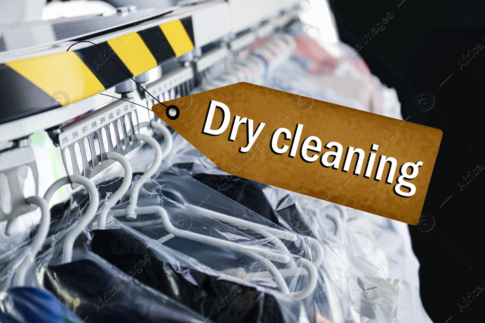 Image of Hangers with clothes on garment conveyor at dry-cleaner's, closeup