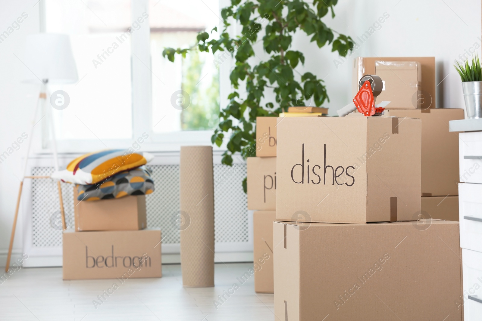 Photo of Moving boxes and household stuff indoors. Space for text