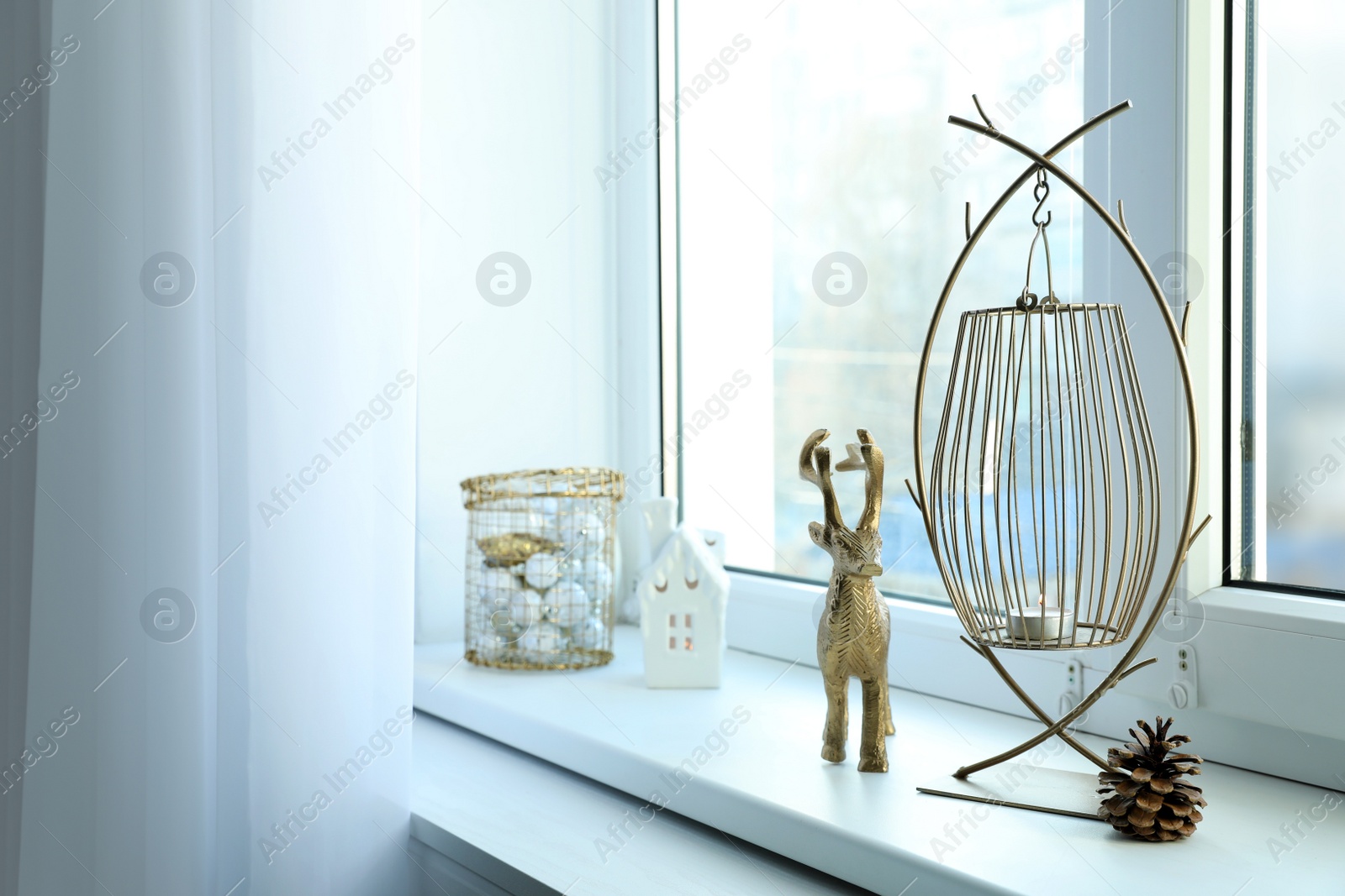 Photo of Beautiful lanterns with burning candles and Christmas decorations on window sill