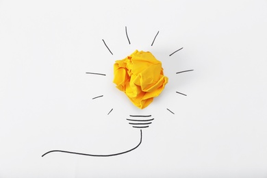 Photo of Composition with crumpled paper ball and drawing of lamp bulb on white background, top view. Creative concept