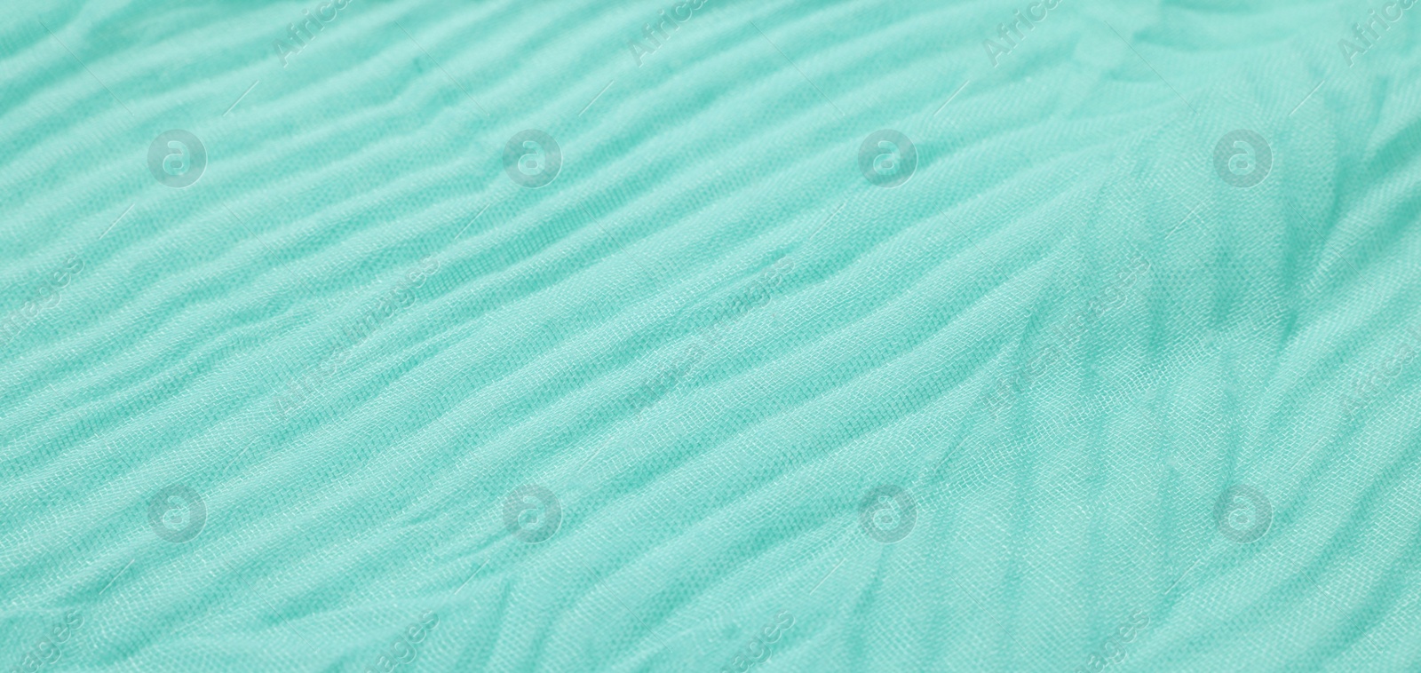 Photo of Texture of turquoise crumpled fabric as background, closeup