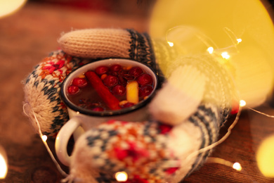 Photo of Woman with mulled wine at wooden table, closeup