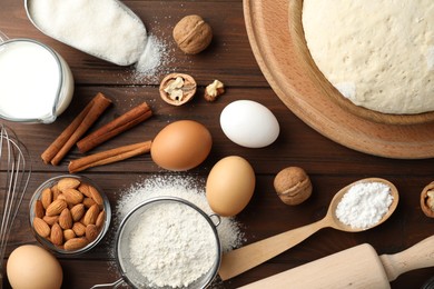 Photo of Dough and ingredients for pastries on wooden table, flat lay