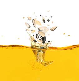 Image of Sunflower seeds falling into cooking oil on white background