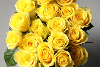 Photo of Beautiful bouquet of yellow roses on grey background, closeup