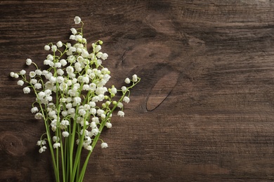 Photo of Fresh spring flowers on wooden background, top view