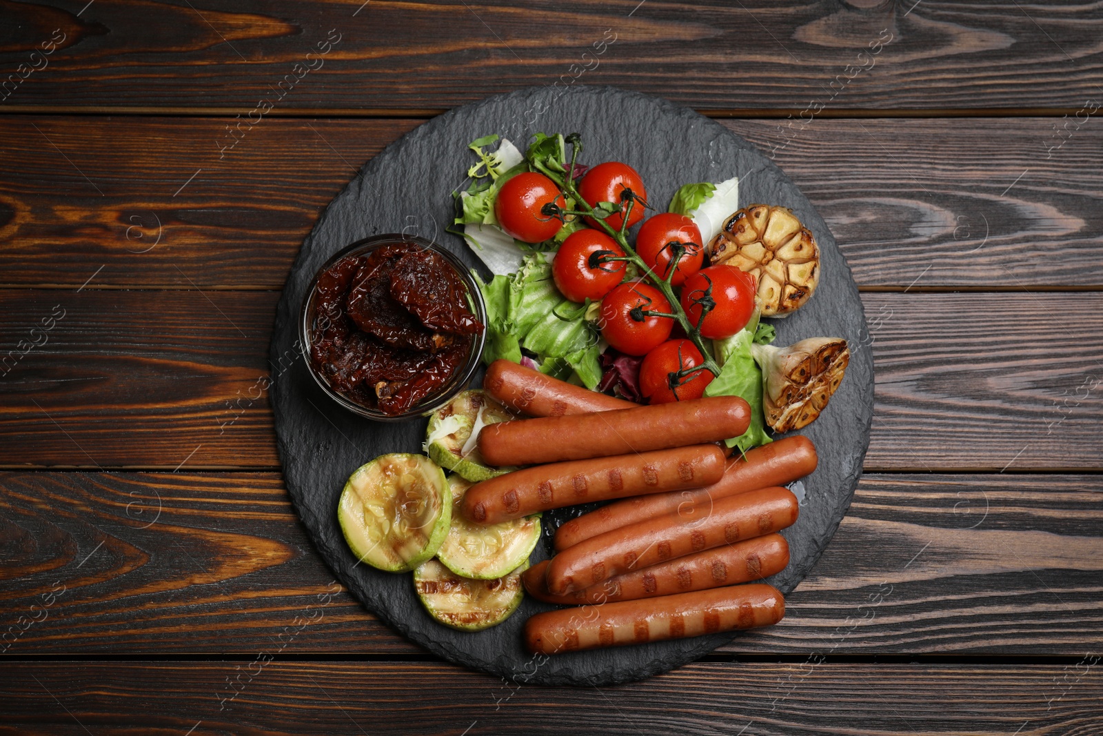 Photo of Tasty grilled sausages served on wooden table, top view