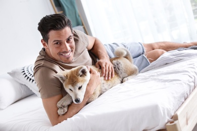 Photo of Man and adorable Akita Inu dog in bedroom