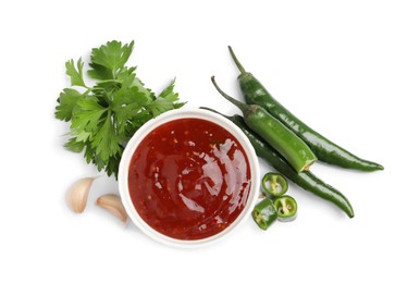 Photo of Spicy chili sauce and ingredients on white background, top view