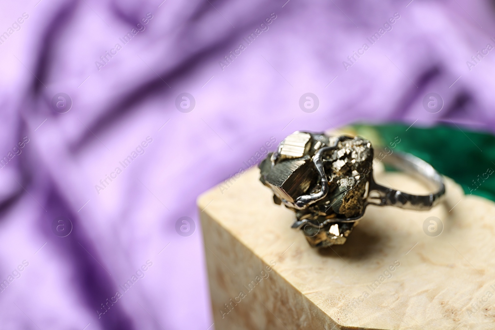 Photo of Beautiful silver ring with pyrite gemstones on color background. Space for text