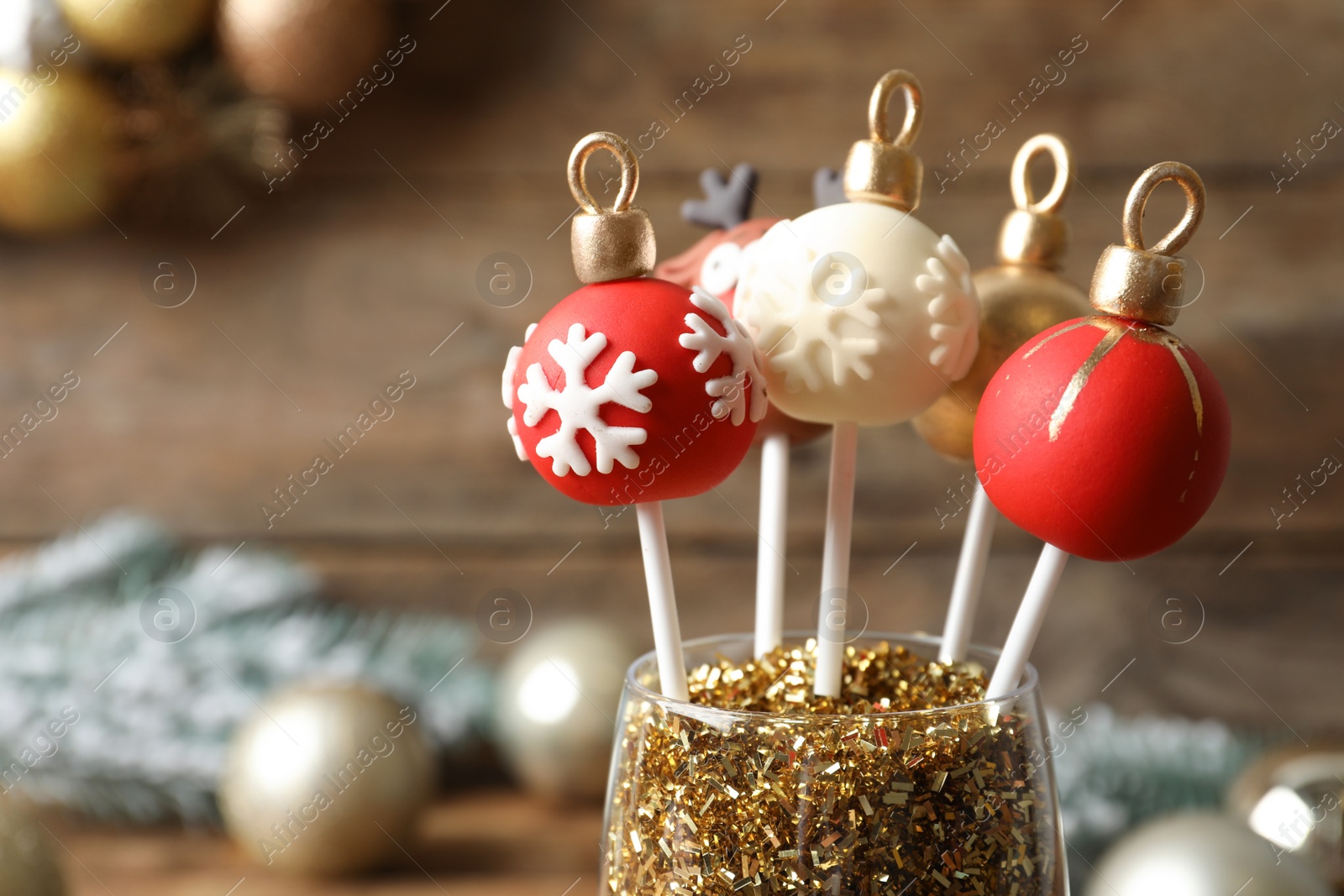 Photo of Delicious Christmas ball cake pops on blurred background, closeup