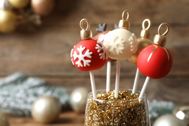 Delicious Christmas ball cake pops on blurred background, closeup