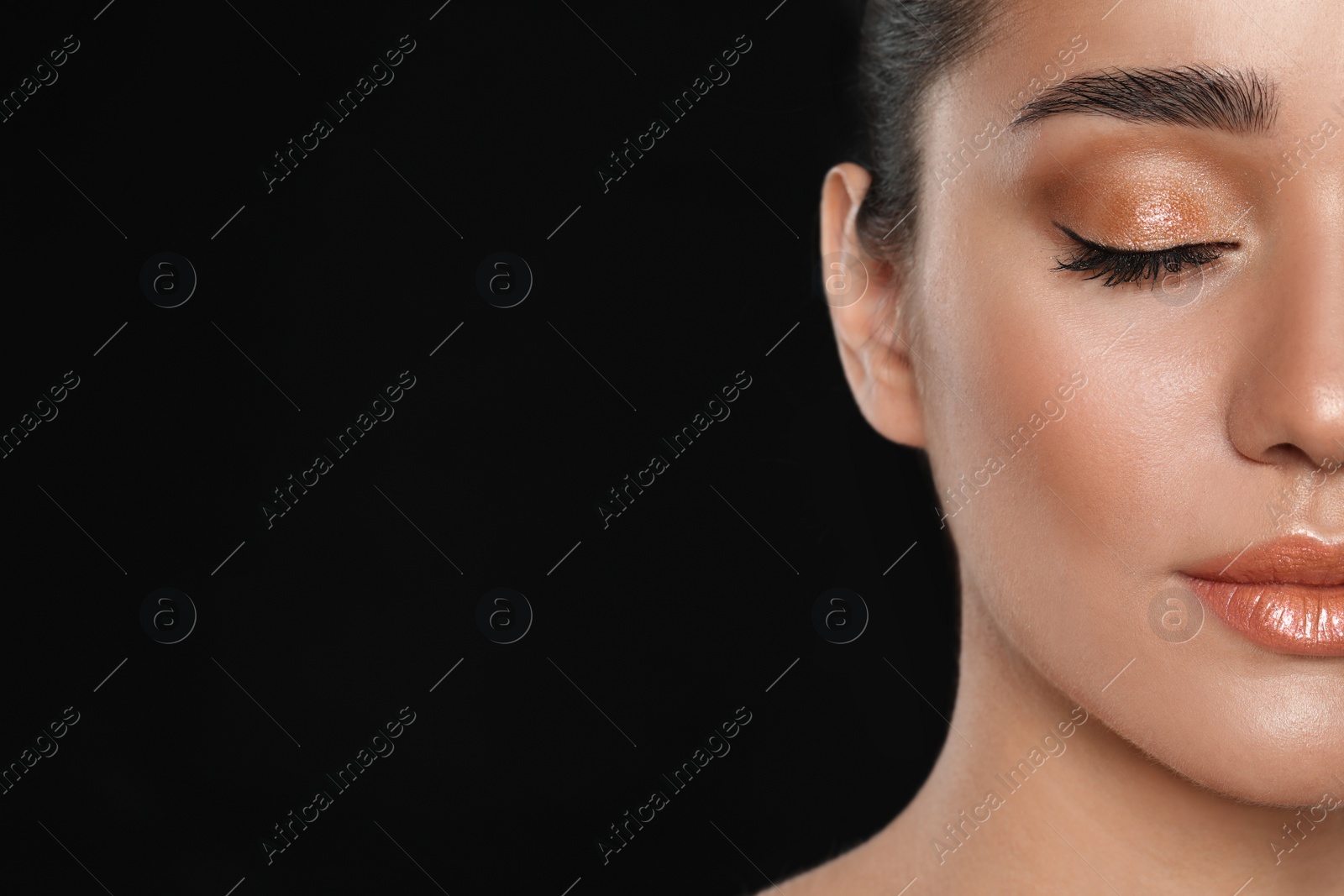 Photo of Beautiful young woman with glitter makeup on black background, closeup view. Space for text