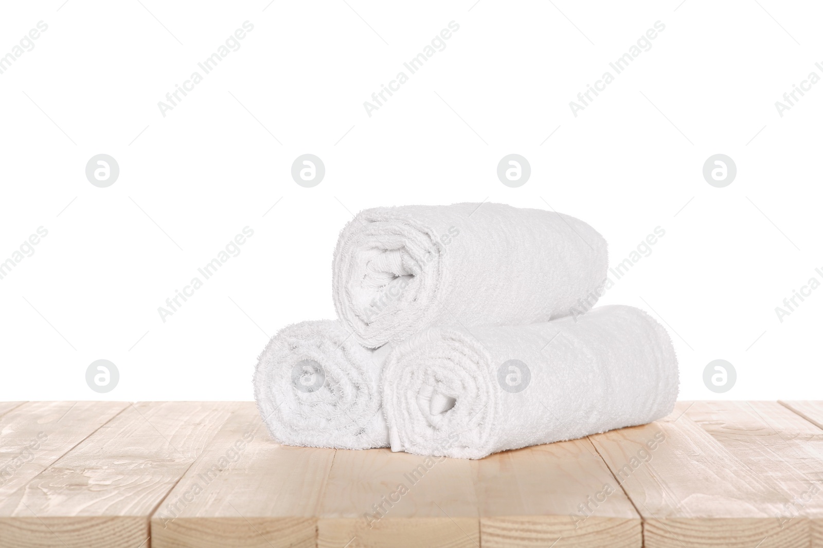 Photo of Soft terry towels on wooden table against white background