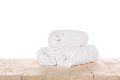Soft terry towels on wooden table against white background