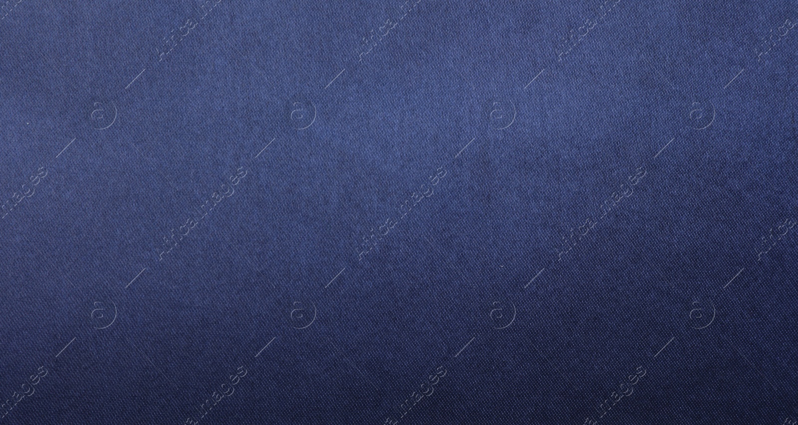 Photo of Texture of dark blue silk fabric as background, top view