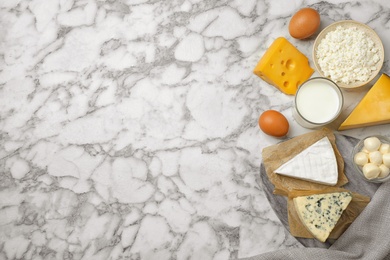 Different dairy products on marble table, flat lay. Space for text