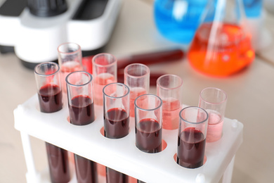 Test tubes with blood samples in rack on table, closeup. Laboratory analysis