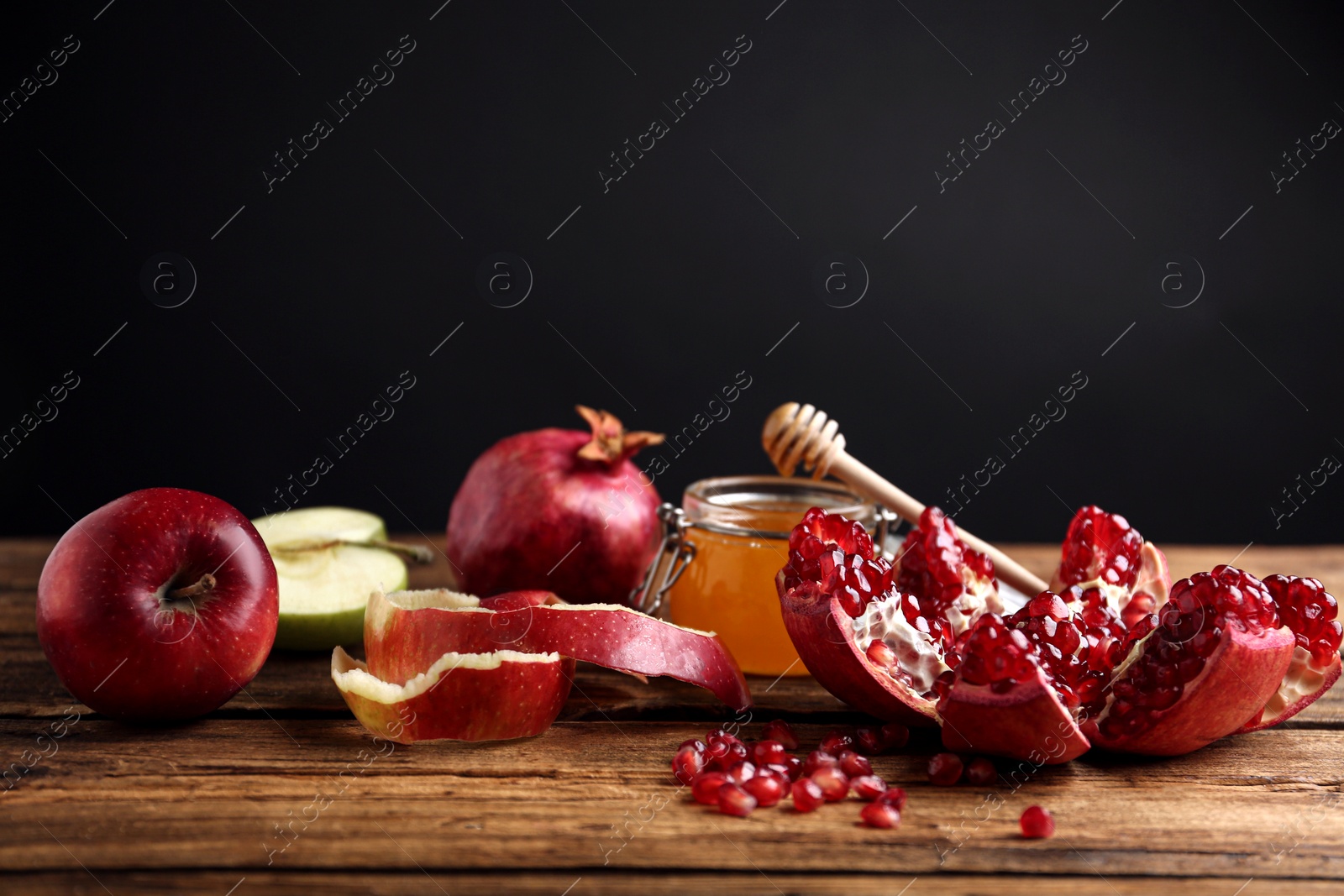 Photo of Honey, apples and pomegranate on wooden table. Rosh Hashanah holiday