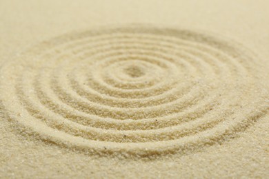 Photo of Zen rock garden. Circle pattern on beige sand, closeup