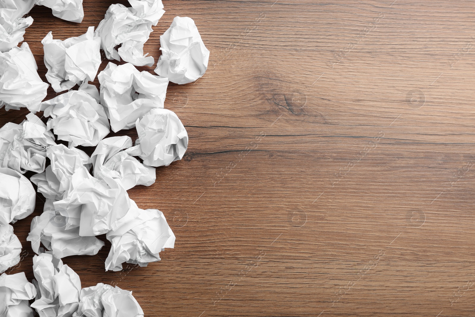 Photo of Crumpled sheets of paper on wooden background, flat lay. Space for text