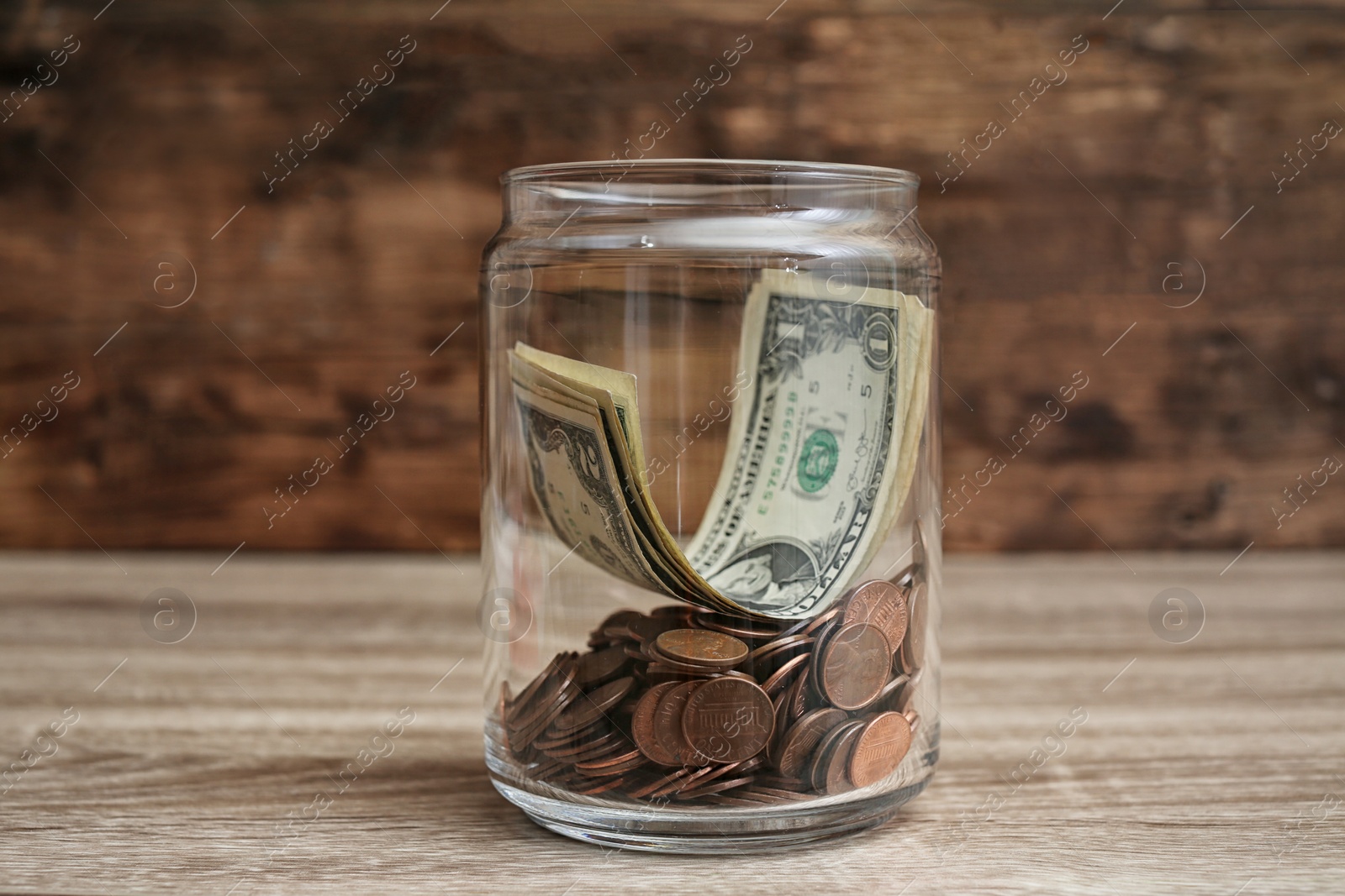 Photo of Donation jar with money on wooden table
