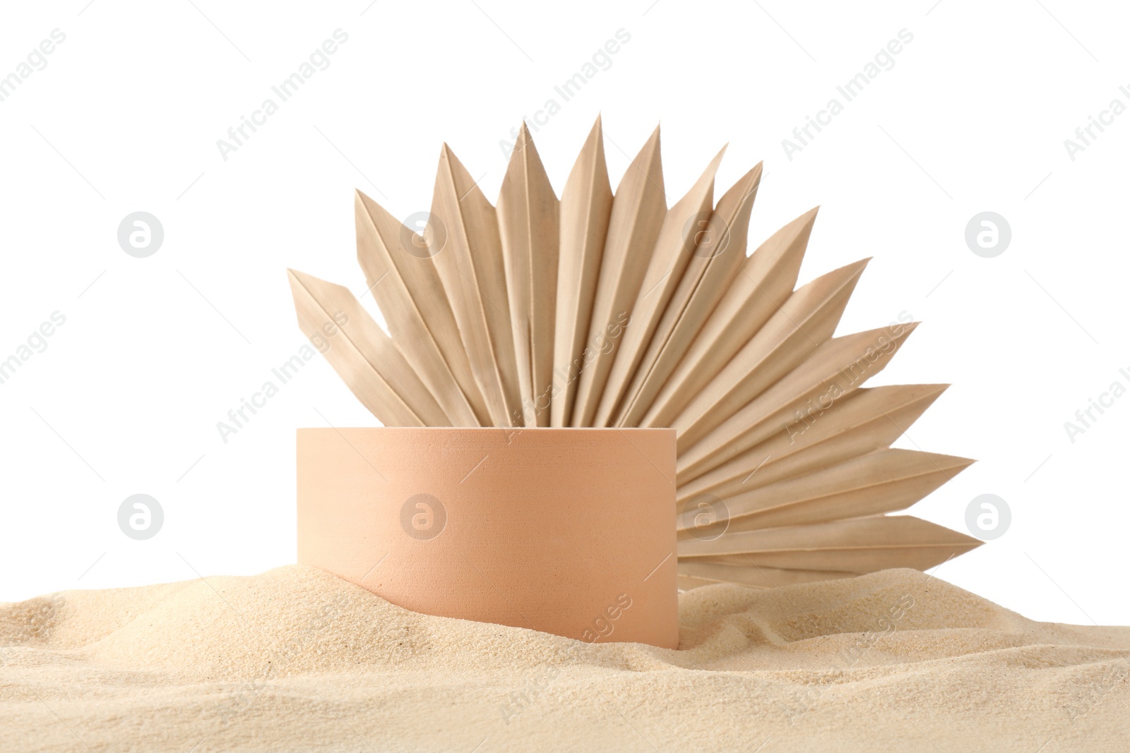 Photo of Presentation of product. Beige podium and palm leaf on sand against white background