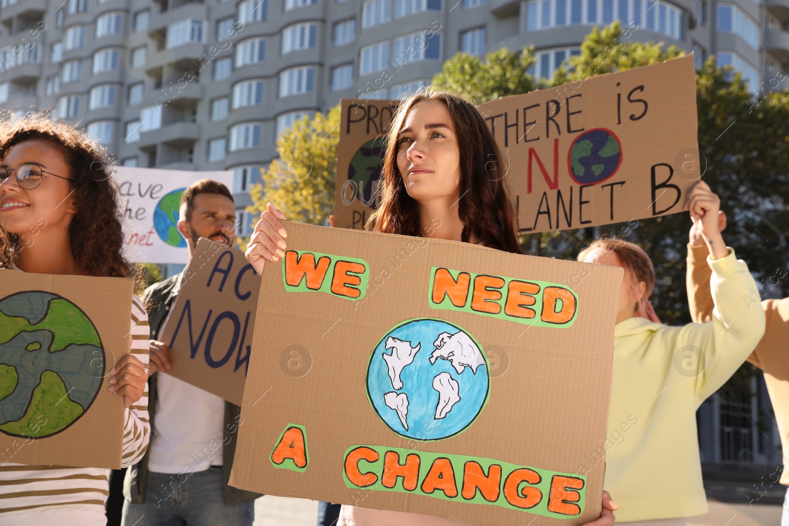 Photo of Group of people with posters protesting against climate change on city street