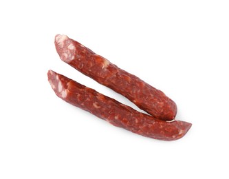 Photo of Thin dry smoked sausages isolated on white, top view