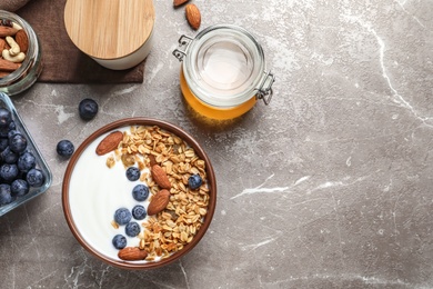 Tasty breakfast with yogurt, berries and granola on table, top view