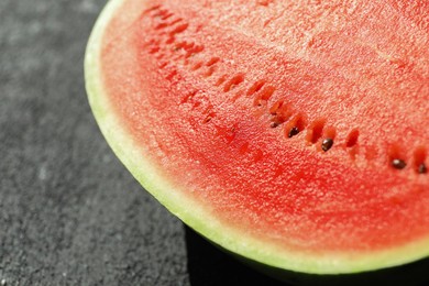 Photo of Half of fresh juicy watermelon on black table, closeup
