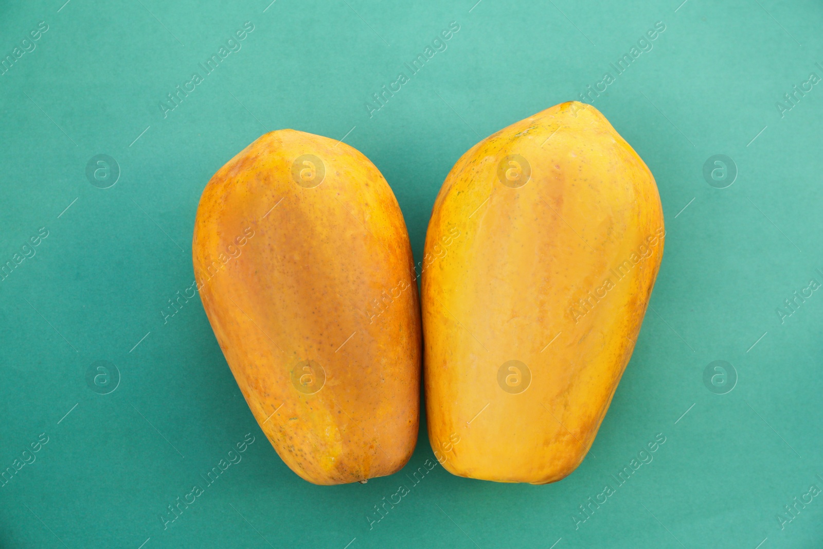 Photo of Fresh ripe papaya fruits on light blue background, flat lay