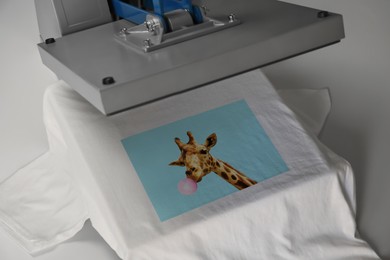 Image of Custom t-shirt. Using heat press to print image of giraffe blowing bubble gum